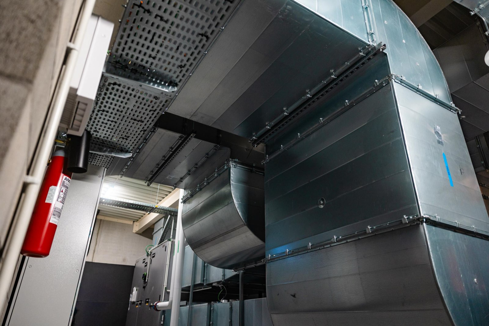 Ventilatiekanalen en luchtgroep in de technische ruimte van de sporthal